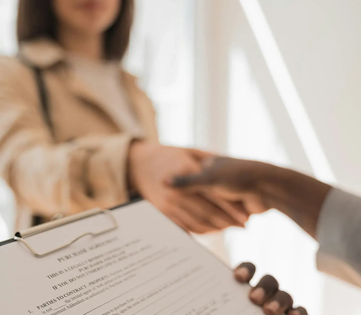 A close-up of a professional handshake between two people. 